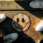 Smiley Face drawn on sidewalk with shoes in frame